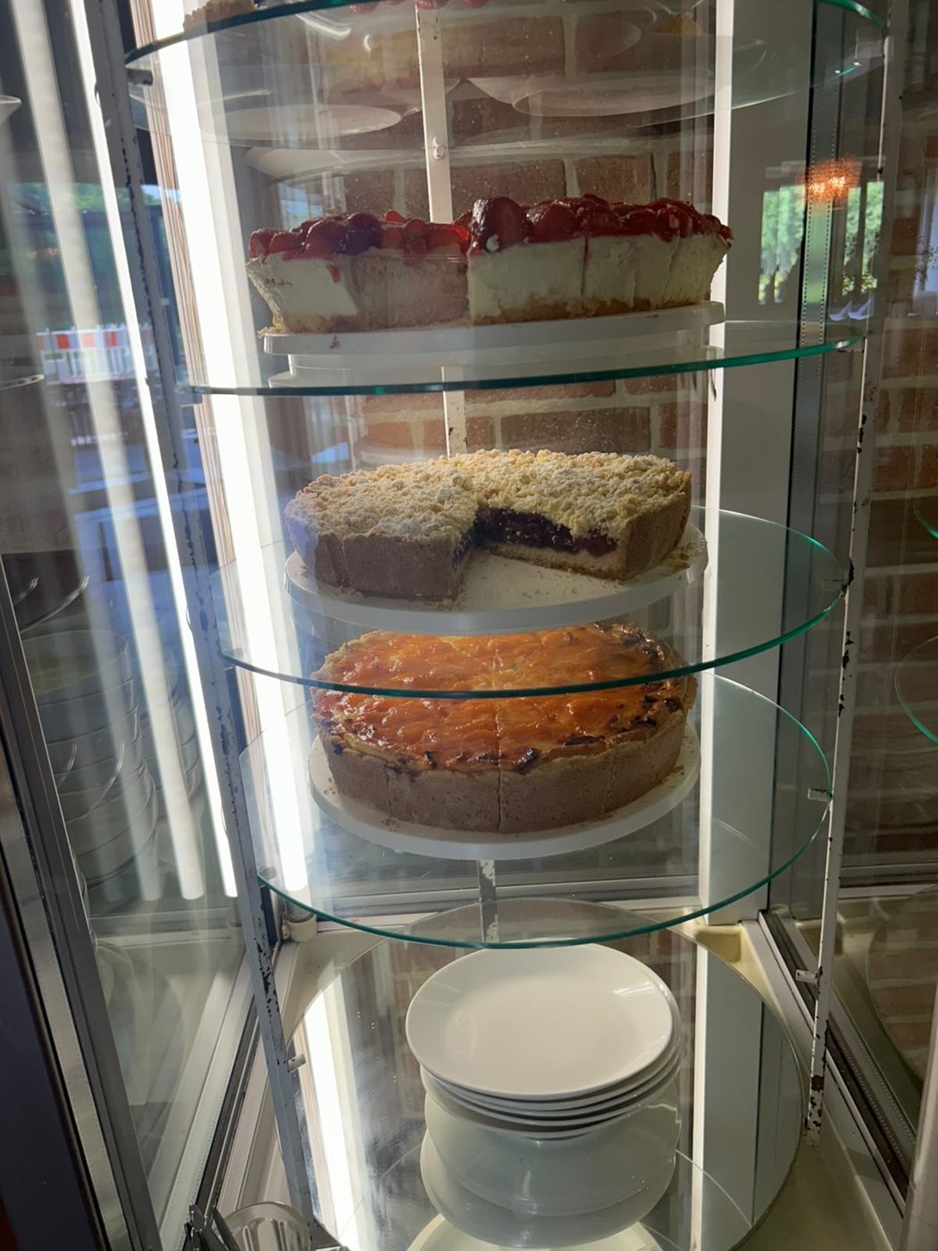 Die Kuchenvitrine mit mehreren Kuchen auf Glasetagen