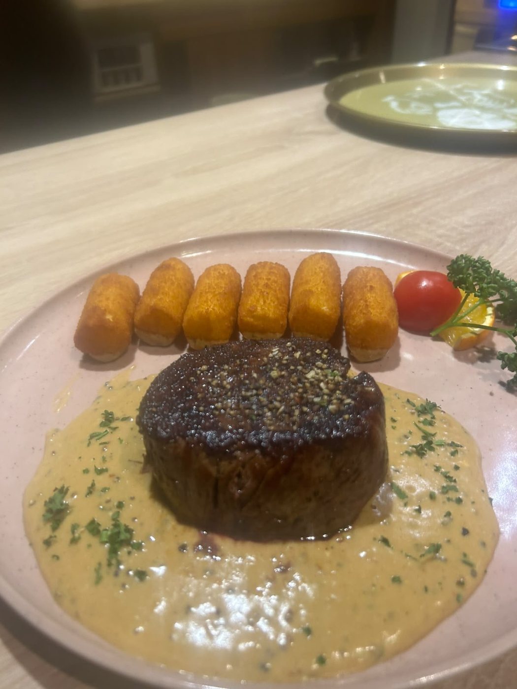 Steak in heller Rahmsoße mit Kroketten und Tomate